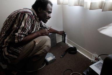 Eddie Williams, 62, glues items such as video cassettes to his walls to stop mice from getting into his Nevin Plaza apartment. Williams, whose rent is $251 a month, asked the Richmond Housing Authority to fix the problem, but he says nothing happened.(Lacy Atkins/San Francisco Chronicle)